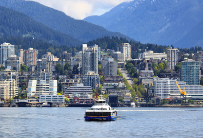 ferry traveling over water with vancouver skyline in the distance.